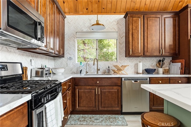 kitchen featuring light stone countertops, appliances with stainless steel finishes, sink, wooden ceiling, and decorative backsplash