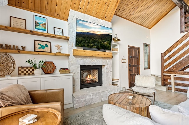 living room featuring wood ceiling, high vaulted ceiling, wood-type flooring, and a fireplace