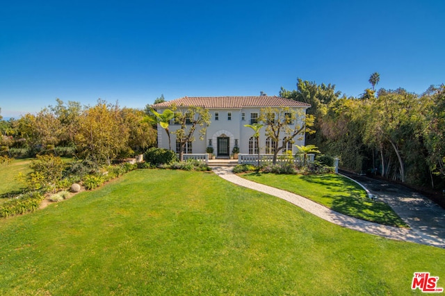 rear view of property featuring a lawn