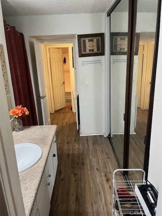 bathroom with vanity, wood-type flooring, and a textured ceiling