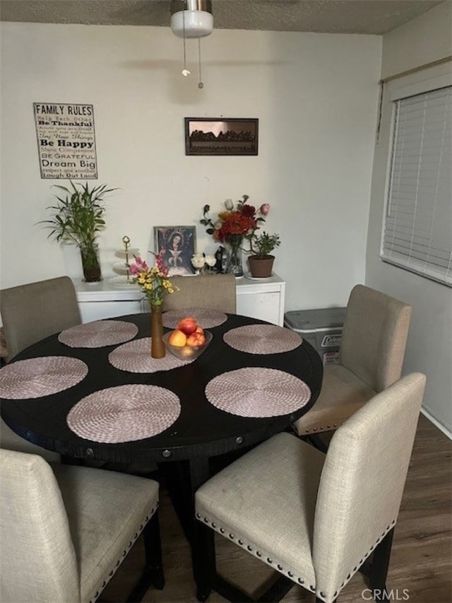 dining space with dark hardwood / wood-style flooring and a textured ceiling