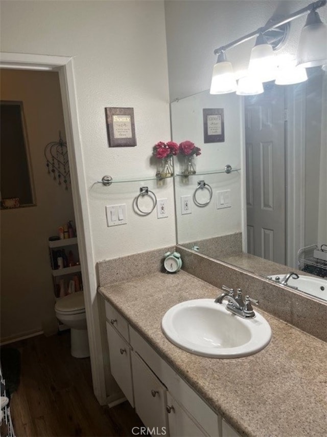 bathroom with vanity, toilet, and wood-type flooring