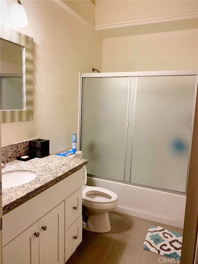 full bathroom featuring vanity, bath / shower combo with glass door, and toilet