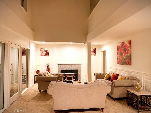 carpeted living room featuring a towering ceiling