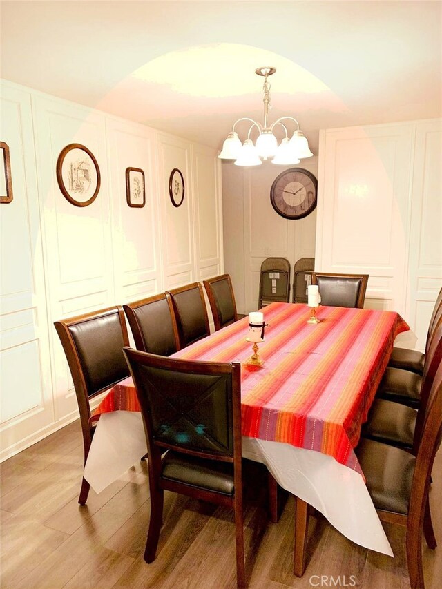 dining room with hardwood / wood-style flooring and a chandelier