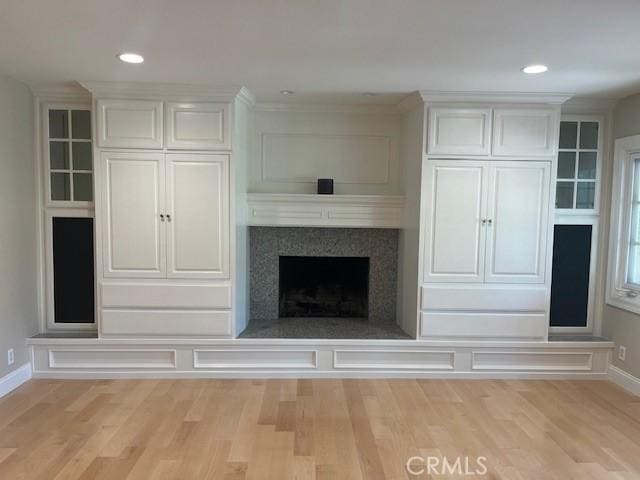 unfurnished living room with a premium fireplace and light wood-type flooring