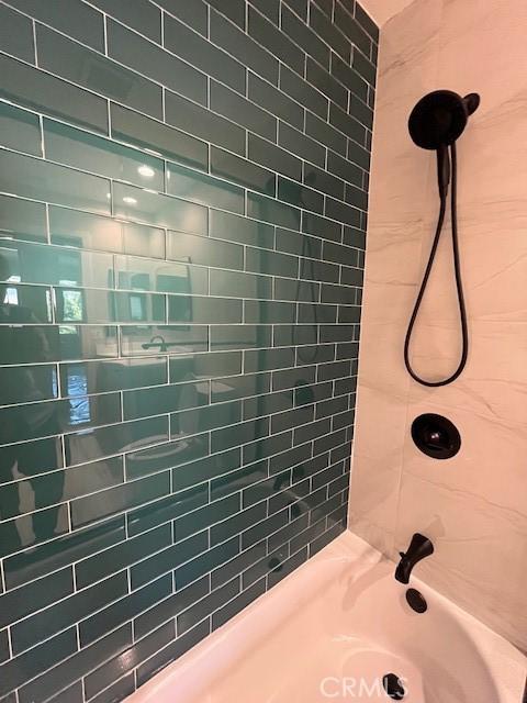 bathroom featuring tiled shower / bath