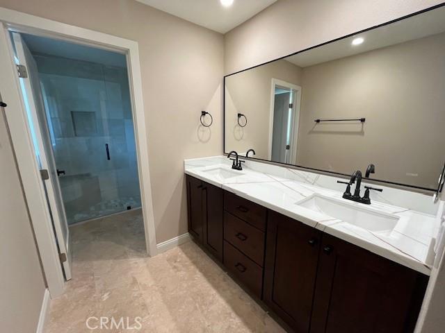 bathroom featuring vanity and a shower with door