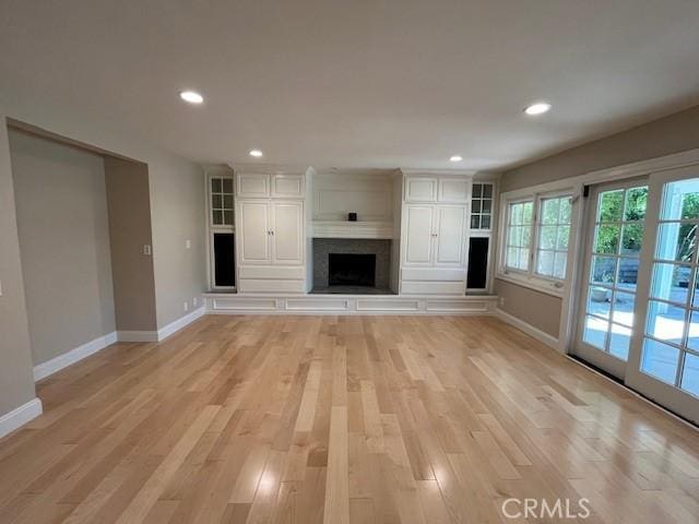 unfurnished living room featuring a fireplace and light wood-type flooring