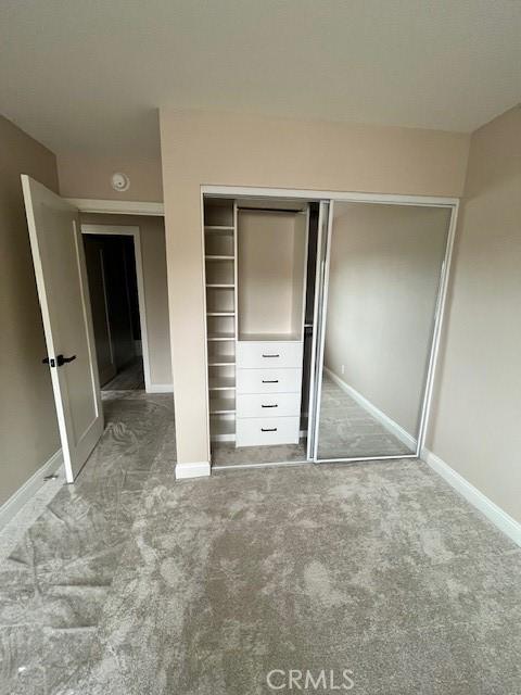 unfurnished bedroom featuring carpet flooring and a closet