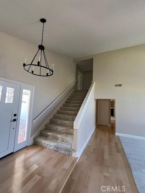 entrance foyer with light wood-type flooring and an inviting chandelier