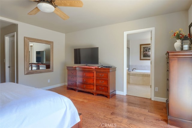 bedroom with ensuite bathroom, light hardwood / wood-style floors, and ceiling fan