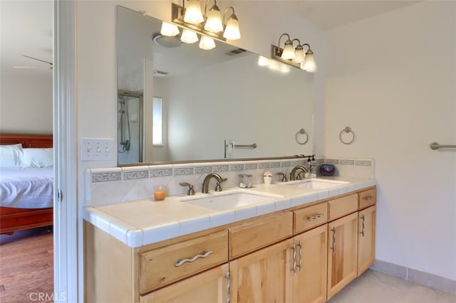 bathroom with vanity, decorative backsplash, a shower with door, and hardwood / wood-style floors