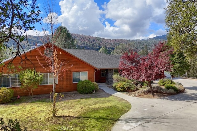 view of front of house featuring a mountain view and a front lawn