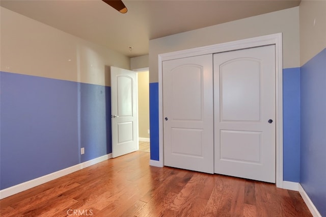 unfurnished bedroom with a closet, ceiling fan, and wood-type flooring