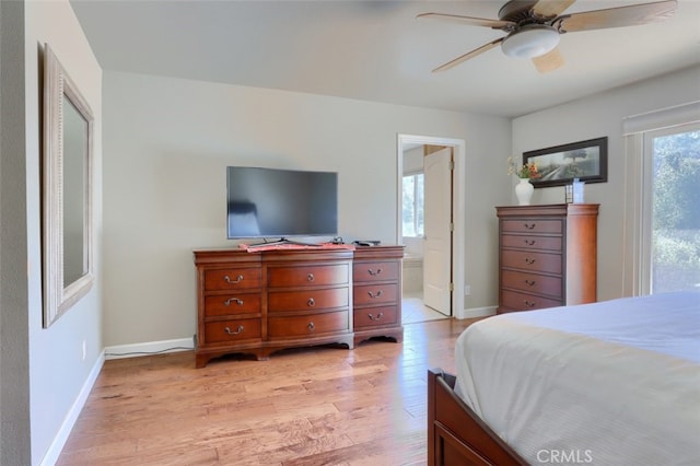 bedroom featuring light hardwood / wood-style flooring, ensuite bathroom, and ceiling fan