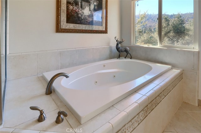 bathroom with tile patterned flooring and tiled tub