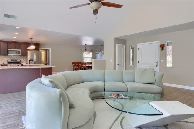 living room with light hardwood / wood-style flooring and ceiling fan