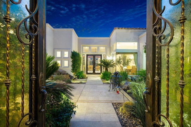 exterior entry at dusk featuring french doors