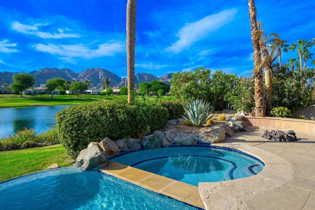 view of swimming pool with a water and mountain view and a hot tub