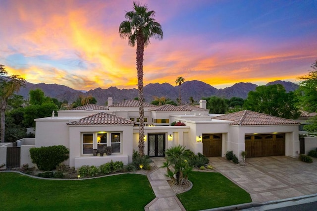 view of front of home featuring a lawn, a mountain view, and french doors