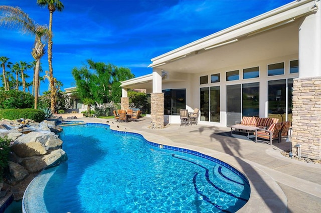 view of pool with an outdoor living space and a patio