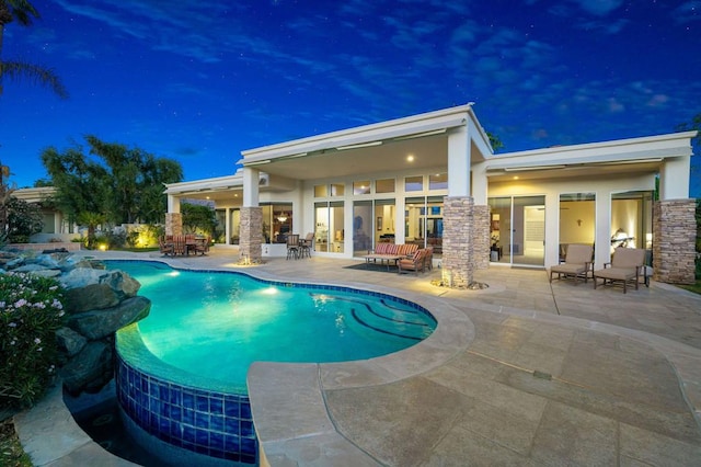 pool at twilight featuring a patio area