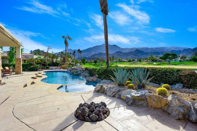 view of swimming pool with a mountain view, pool water feature, and a patio