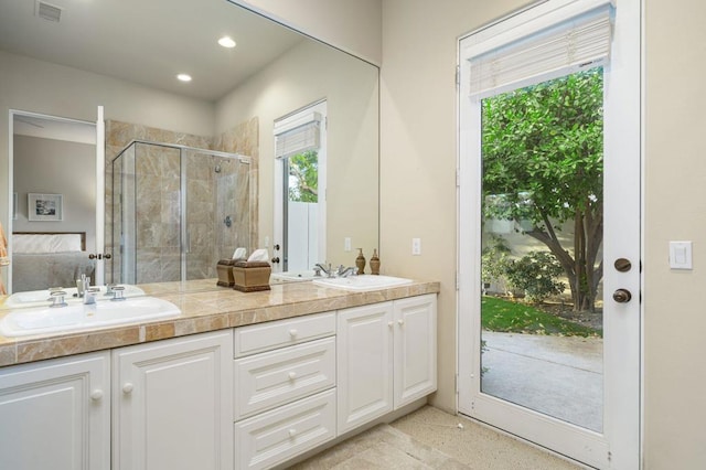 bathroom featuring vanity and a shower with door