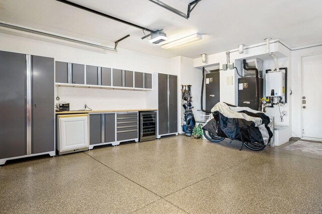 garage with wine cooler, a garage door opener, and water heater