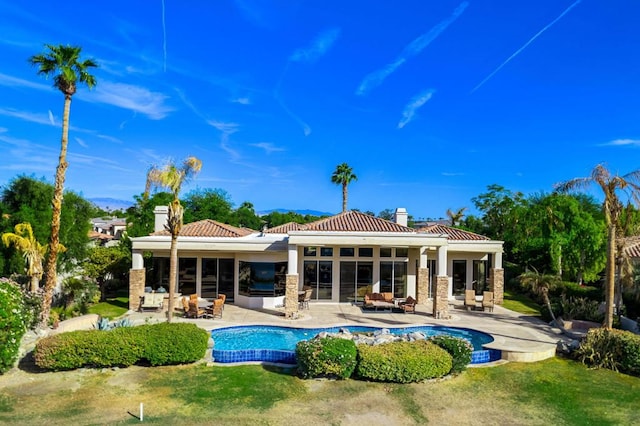 back of house with a lawn, exterior kitchen, and a patio