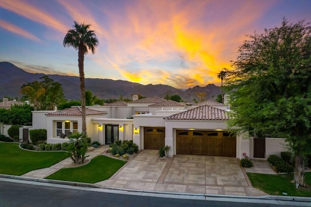 mediterranean / spanish-style home with a mountain view and a yard