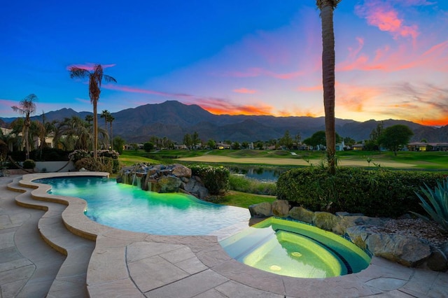 pool at dusk with a mountain view and an in ground hot tub