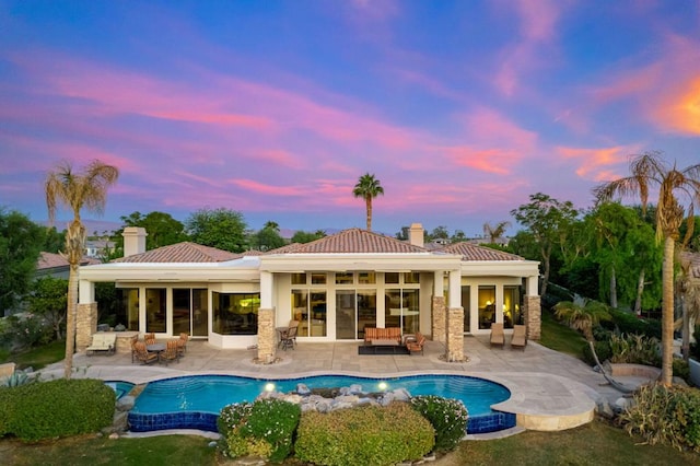 back house at dusk with an outdoor hangout area and a patio