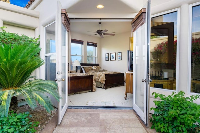 sunroom / solarium featuring ceiling fan and french doors