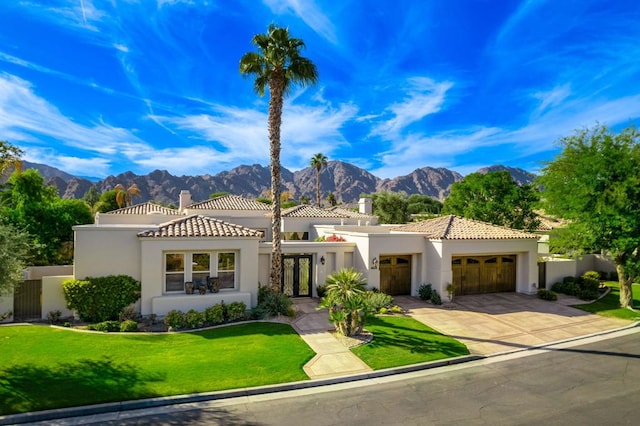 mediterranean / spanish-style house featuring a mountain view, a garage, and a front yard