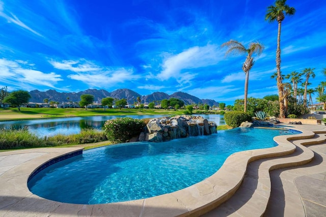 view of swimming pool with pool water feature and a water and mountain view