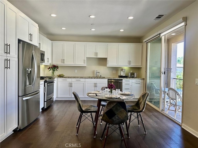 kitchen with white cabinets, dark wood-type flooring, sink, and stainless steel appliances