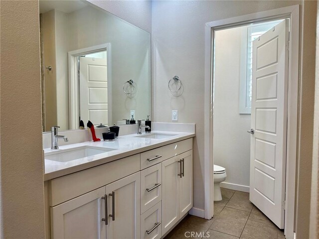 bathroom featuring toilet, vanity, and tile patterned flooring