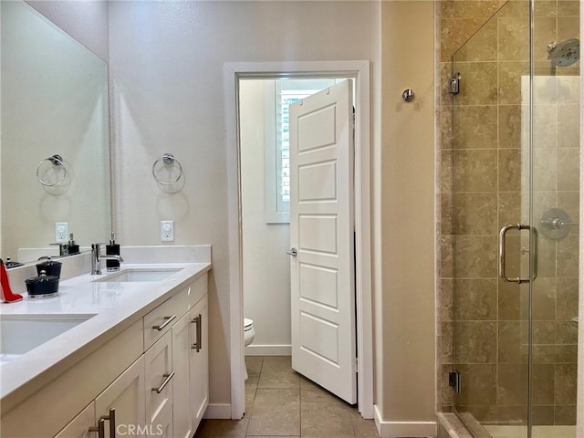 bathroom featuring toilet, vanity, tile patterned flooring, and walk in shower