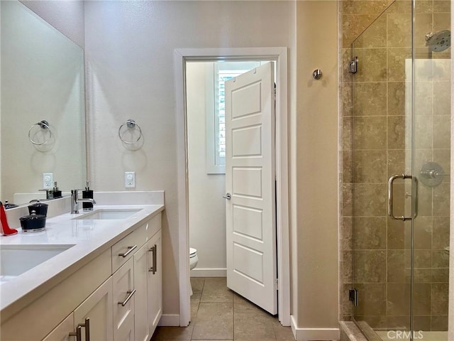 full bathroom featuring a sink, toilet, a stall shower, and tile patterned floors