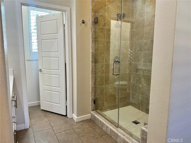 bathroom featuring tile patterned floors and a shower with door