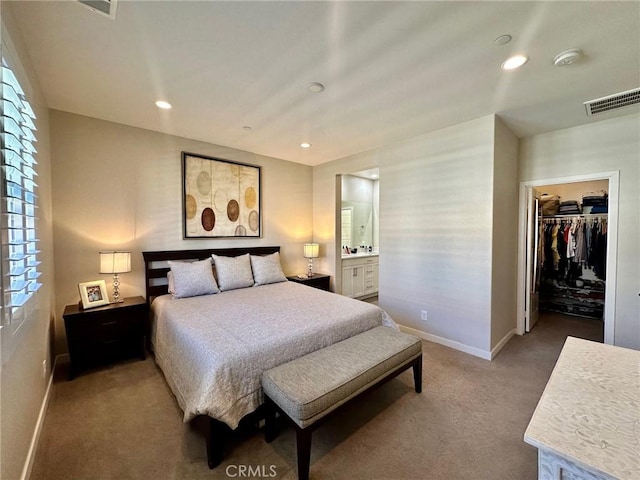 carpeted bedroom featuring a spacious closet, a closet, and connected bathroom