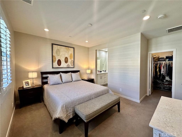 bedroom with carpet, visible vents, baseboards, recessed lighting, and a walk in closet