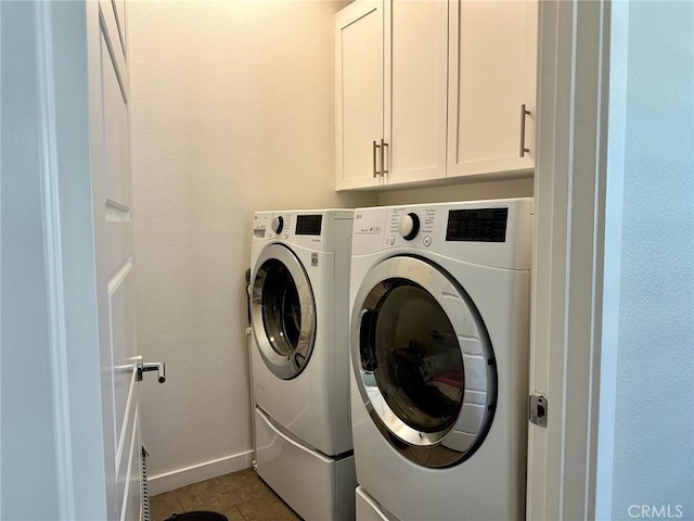 washroom featuring cabinets, light tile patterned flooring, and independent washer and dryer