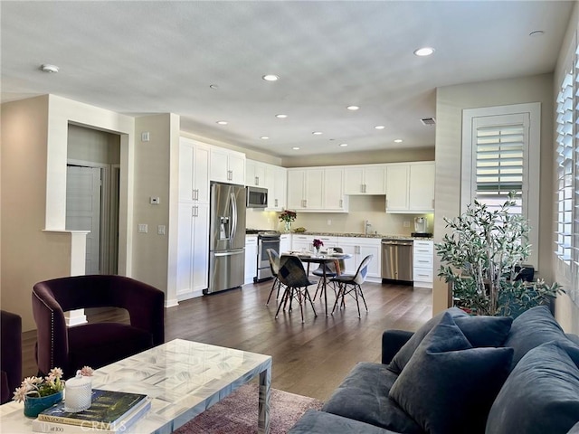 living room featuring recessed lighting and dark wood-style flooring