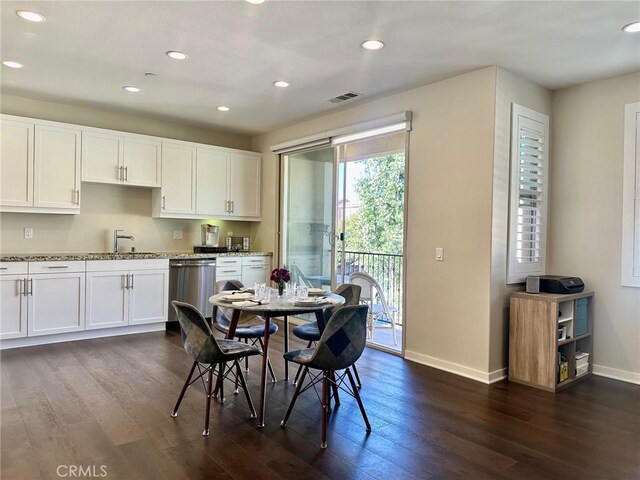 kitchen featuring dishwasher, sink, white cabinetry, dark wood-type flooring, and light stone countertops