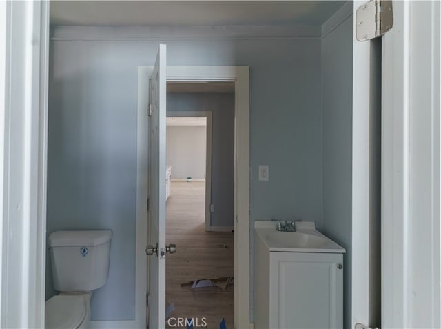 bathroom featuring toilet, hardwood / wood-style flooring, and vanity