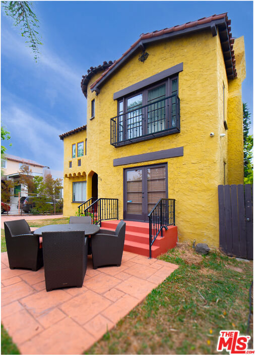 rear view of house featuring a patio area and a balcony