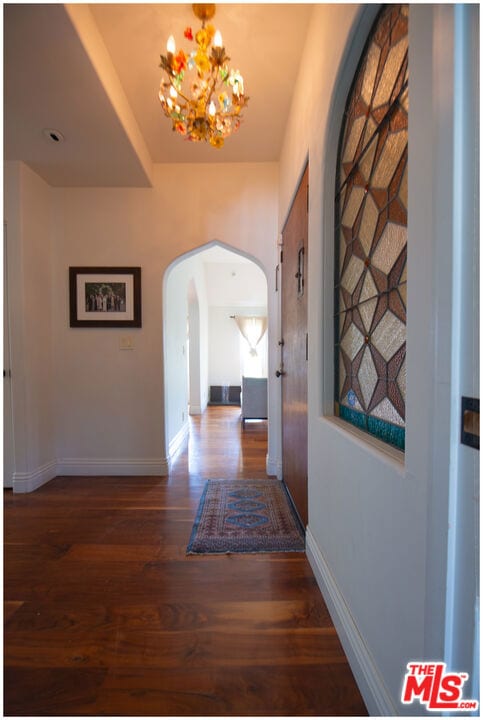 hall featuring dark hardwood / wood-style flooring and a notable chandelier